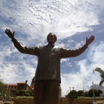 Helicopters fly past a 9-metre bronze statue of Nelson Mandela after it was unveiled at the Union Buildings in Pretoria